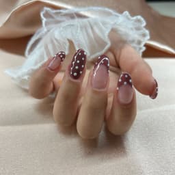 A warm nude base with deep mocha tips and delicate white dots a perfect mix of vintage charm and modern vibes. For those who love something subtle yet eye catching 💅🤍