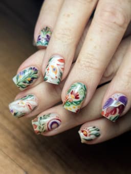 Square nails with bold hand-painted designs in vibrant colours, featuring intricate floral and abstract patterns – a bespoke set by MissbehaveNails in Leighton Buzzard.