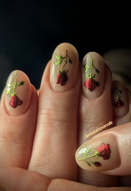 Neutral base nails with detailed hand-painted red roses and green stems – a striking floral design by MissbehaveNails in Leighton Buzzard.