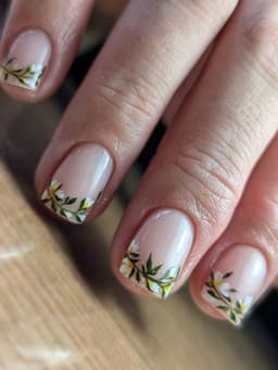 Soft nude nails with delicate hand-painted floral designs in green and white – a bespoke manicure crafted at MissbehaveNails in Leighton Buzzard.