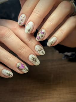 Hand-painted celestial nail art with stars, hearts, and detailed linework on a soft base – a bespoke design by MissbehaveNails in Leighton Buzzard.