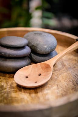 Hot stone massage therapy in Hastings – natural volcanic stones used at In Tune Massage Therapy for relaxation and chronic pain relief.