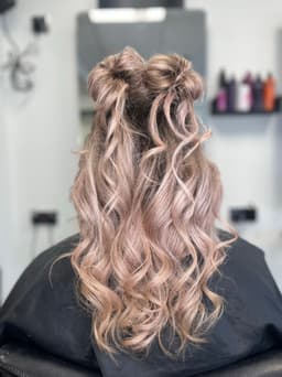 Half-up curly hairstyle with soft waves and double buns at Rhubarb Hair, Beauty & Barbers in Stockton-on-Tees – a fun and stylish look.