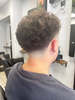 Fresh skin fade haircut with natural curls at Rhubarb Hair, Beauty & Barbers in Stockton-on-Tees – modern barbering for gents.